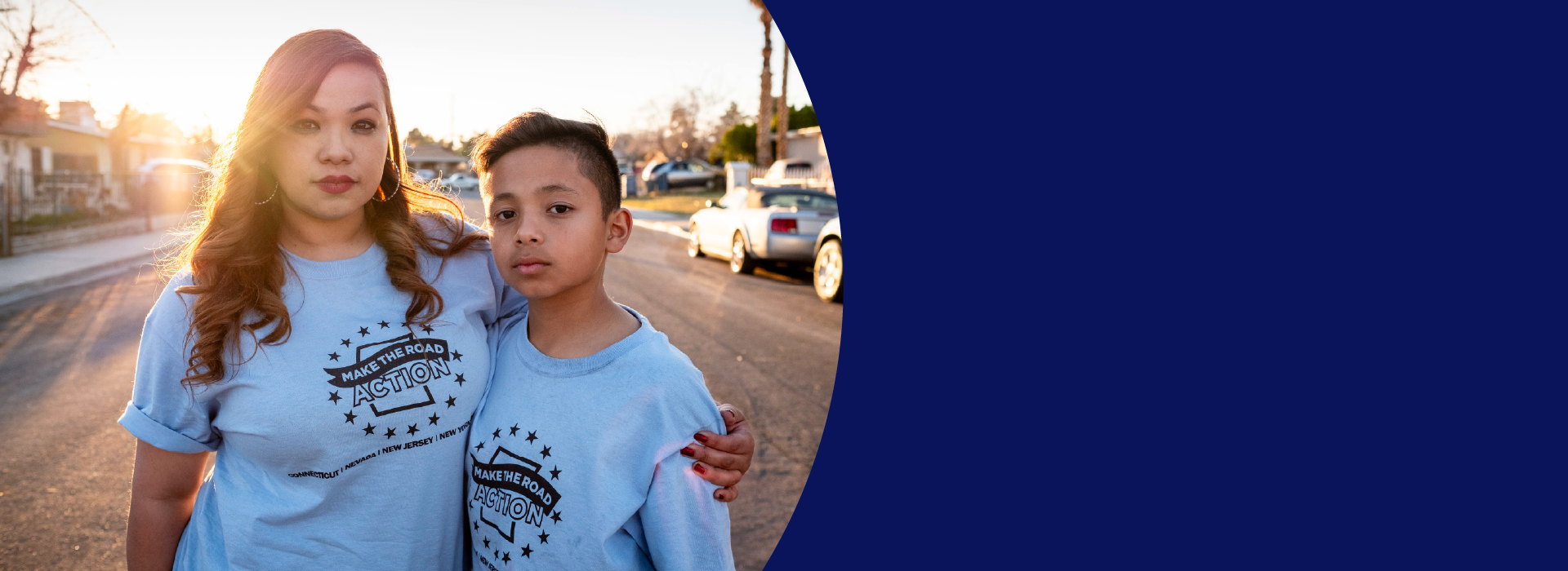 A mother and her son, both wearing light blue tshirts that say Make The Road Action.