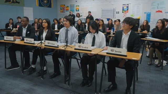 six people sit at a horizontal table