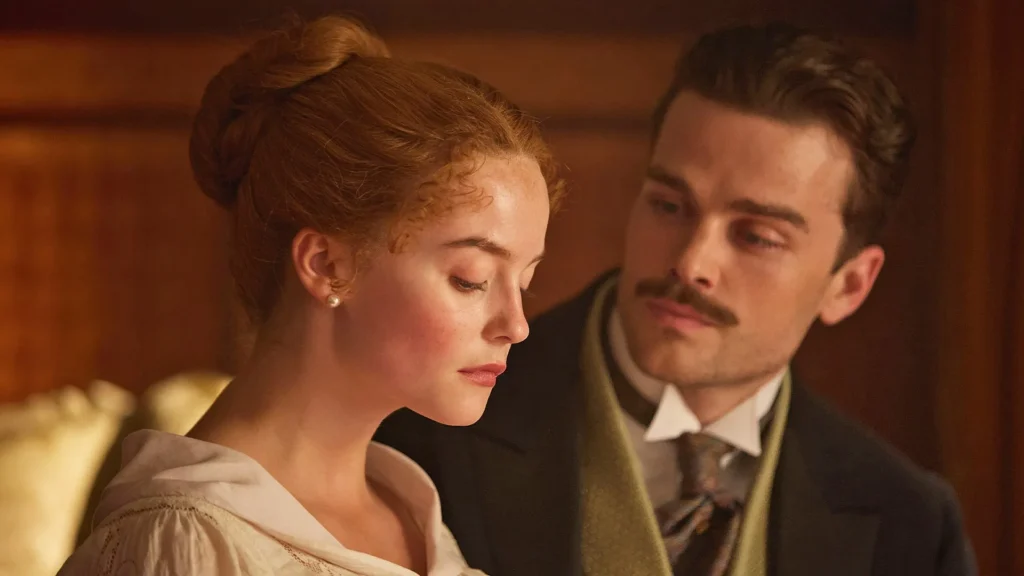 A gentleman in a suit sits and stares longingly at a red haired woman next to him.