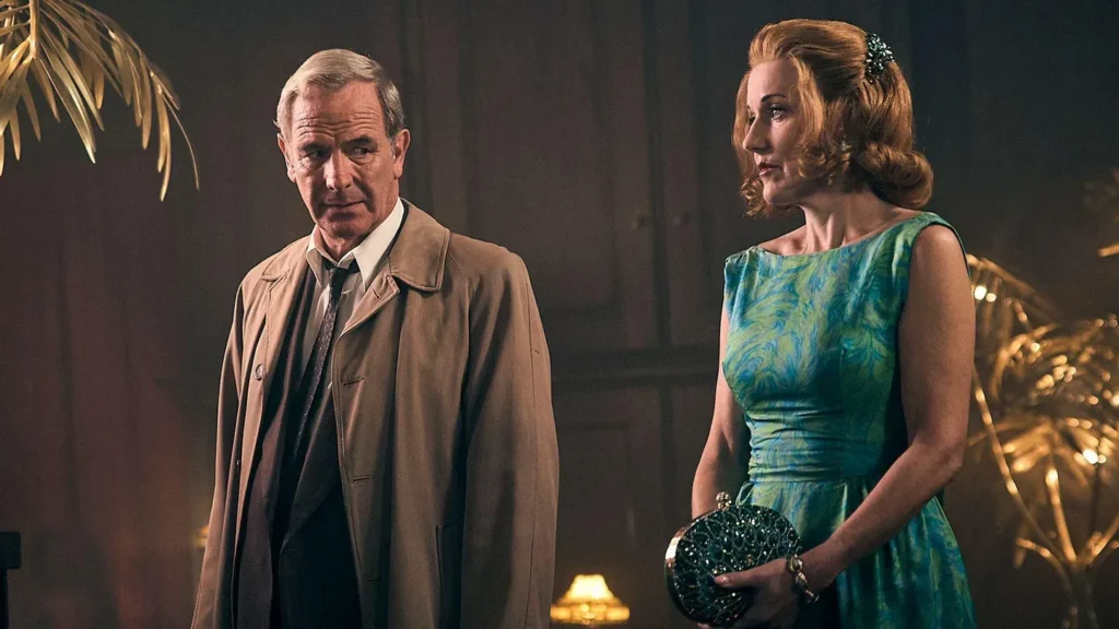 A middle aged man wearing a tan trench coat looks to his side, where a woman wearing a blue dress clutches her purse and looks at something out of view.