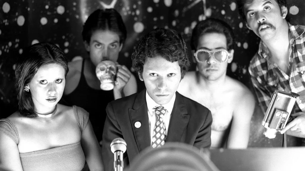 Members of ASCO, the Chicana art group, stare up at the camera dramatically in this black and white photo from the '70s.